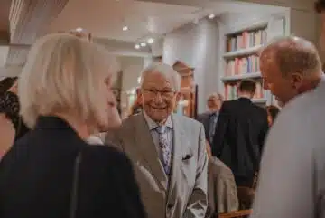smiling man wearing suit standing beside man